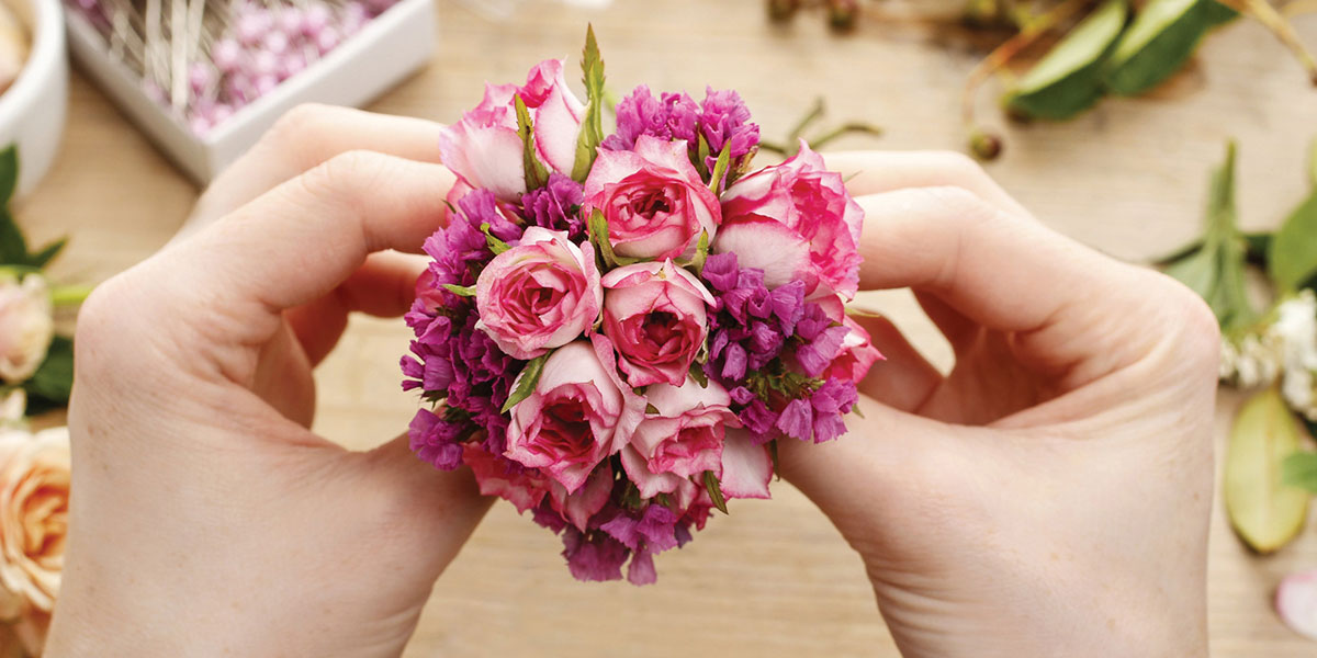 Hands preparing bouquet.