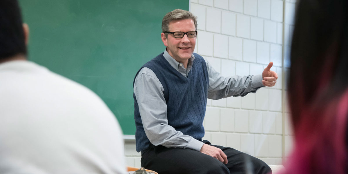 Faculty gesturing in front of class