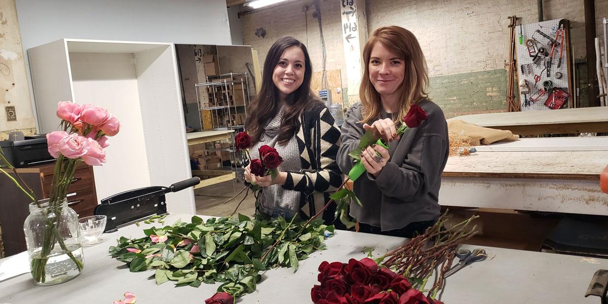 学生萨·格雷-福尔曼和导师卡莉·瑟曼拿着鲜花.